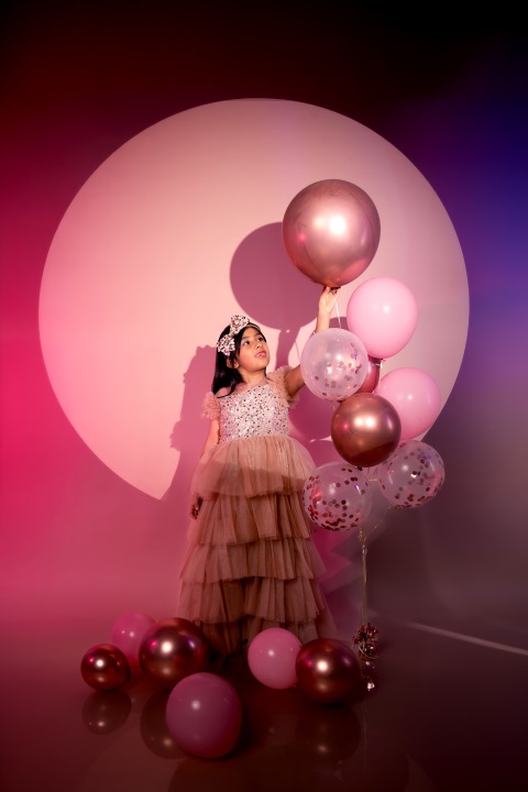 Retrato de niña con globos rosados