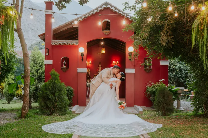 Pareja de novios frente a una casa roja